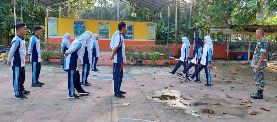 Babinsa Koramil 04/Pasir Penyu Kodim 0302/Inhu Latih PBB Siswa-Siswi SMKN 1 Lubuk Batu Jaya